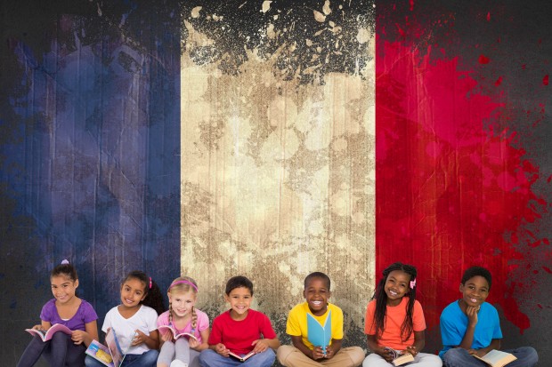 Crianças francesas de pré-escola sentadas em frente a uma parede pintada com as cores da bandeira da França