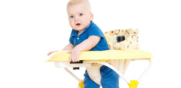 The small child learns to walk by means of Baby walker on a white background.