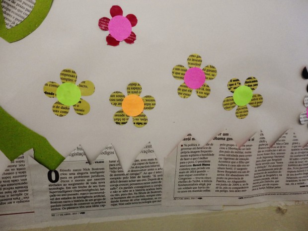 Detalhes de painel para biblioteca feito com jornais, livros usados e papéis coloridos