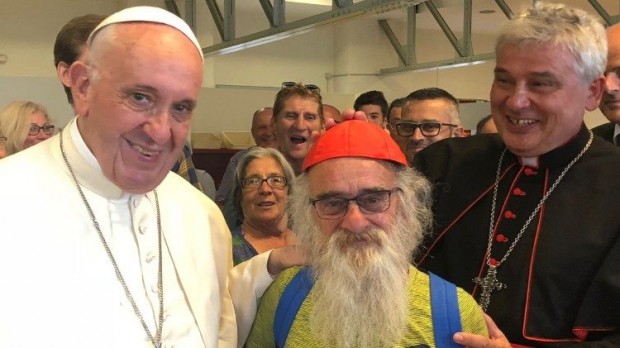Krajewski brinca e coloca o seu solidéu em um dos pobres convidados para o evento. Foto: Vatican News